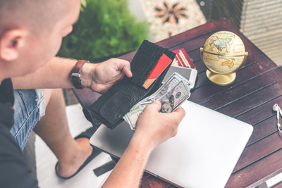 A photo of a man counting the money in his wallet