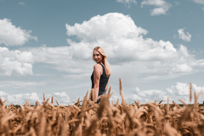 A Ukrainian woman on a polka dot dress standing in the field.