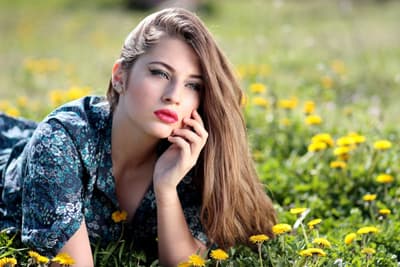 A Ukrainian woman laying on a grass field.