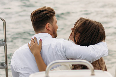 A photo of a man and woman facing the ocean