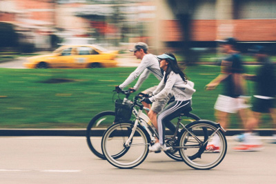 An image of a couple riding a bicycle together. 