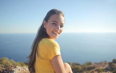 A photo of a smiling Ukrainian woman in a yellow shirt